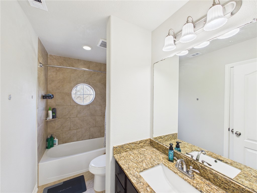 10645 C Hoppess Road Franklin, TX 77856 - Photo 30 of 50 a bathroom with a granite countertop sink a toilet and bathtub