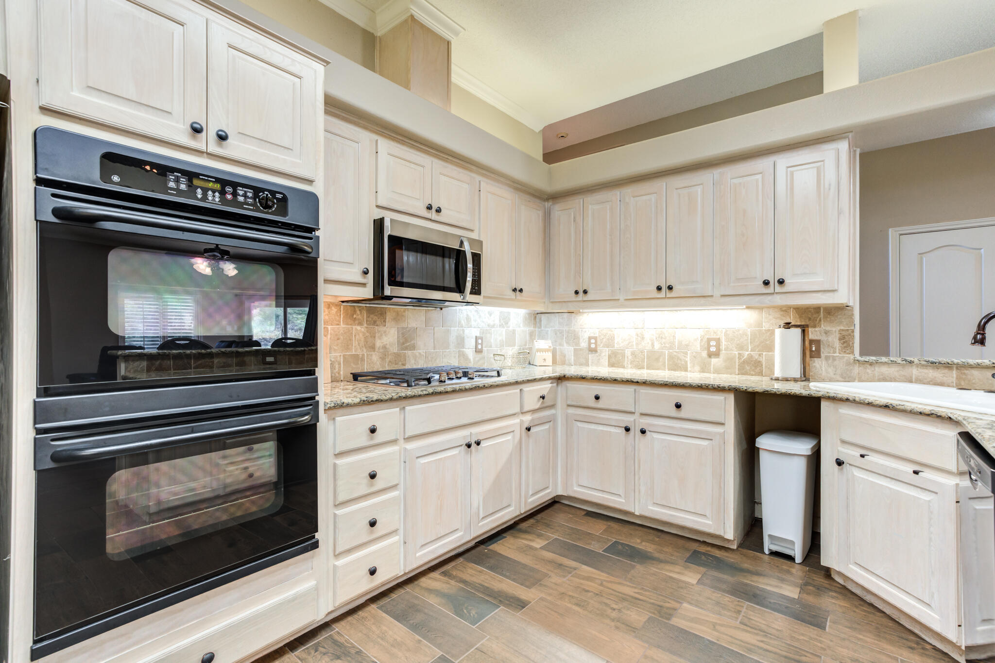 1 Squaw Lane Ransom Canyon, TX 79366 - Photo 32 of 74 a kitchen with granite countertop cabinets stainless steel appliances and white cabinets