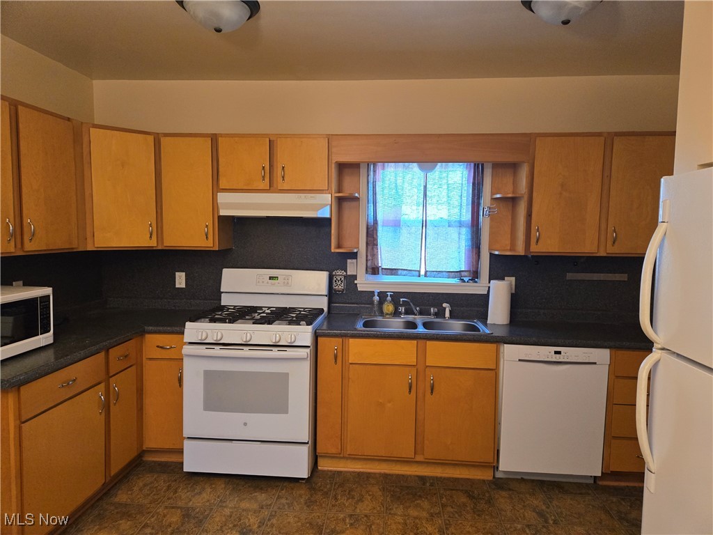 1962 Zenobia Road Norwalk, OH 44857 - Photo 3 of 30 Kitchen with under cabinet range hood, white appliances, a sink, open shelves, and dark countertops