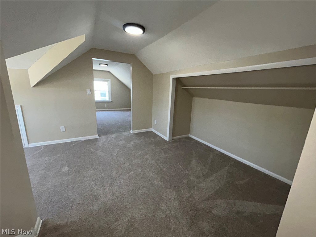 9316 Alexander Road Garfield Heights, OH 44125 - Photo 14 of 27 Gray carpeted flooring, sloped ceiling, flush mount lighting, built-in open closet, and window
