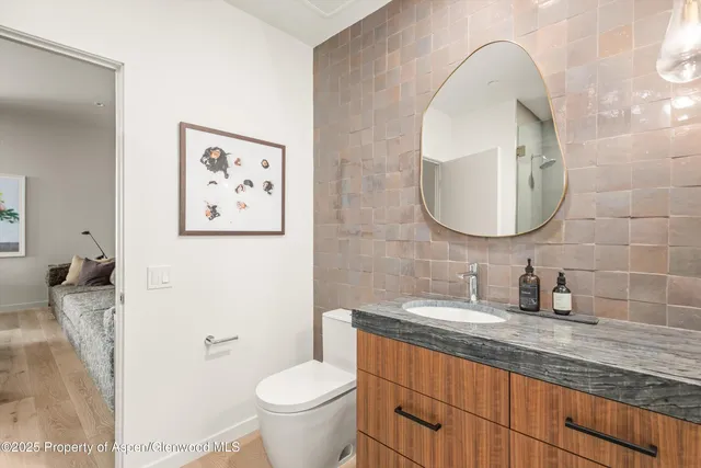 a bathroom with a toilet sink and mirror