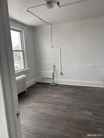 a view of a room with wooden floor and window