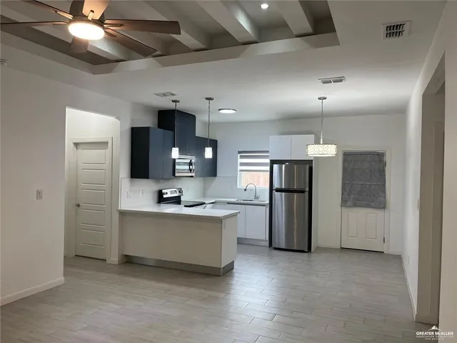 a view of kitchen with sink refrigerator and window