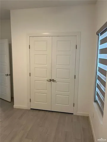 an empty room with a hardwood and white doors