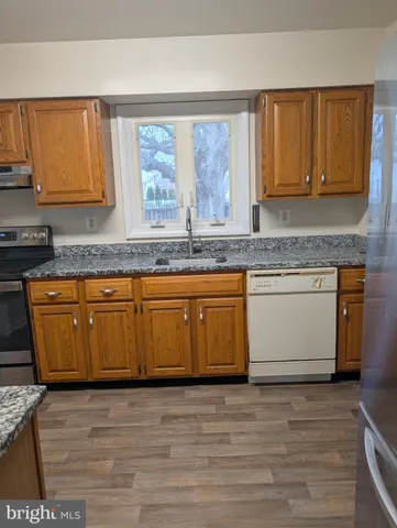 a view of a kitchen with wooden floor and cabinets