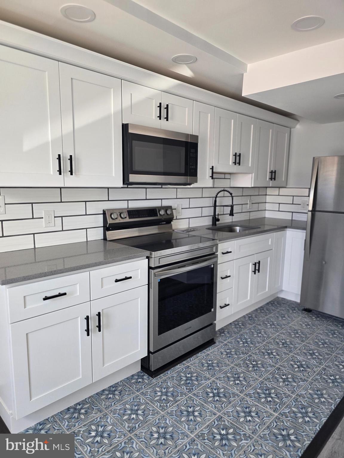 5925 Ridge Avenue, Unit 5 Philadelphia, PA 19128 - Photo 29 of 31 a kitchen with a sink stove and microwave