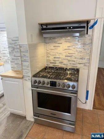 a stove top oven sitting inside of a kitchen