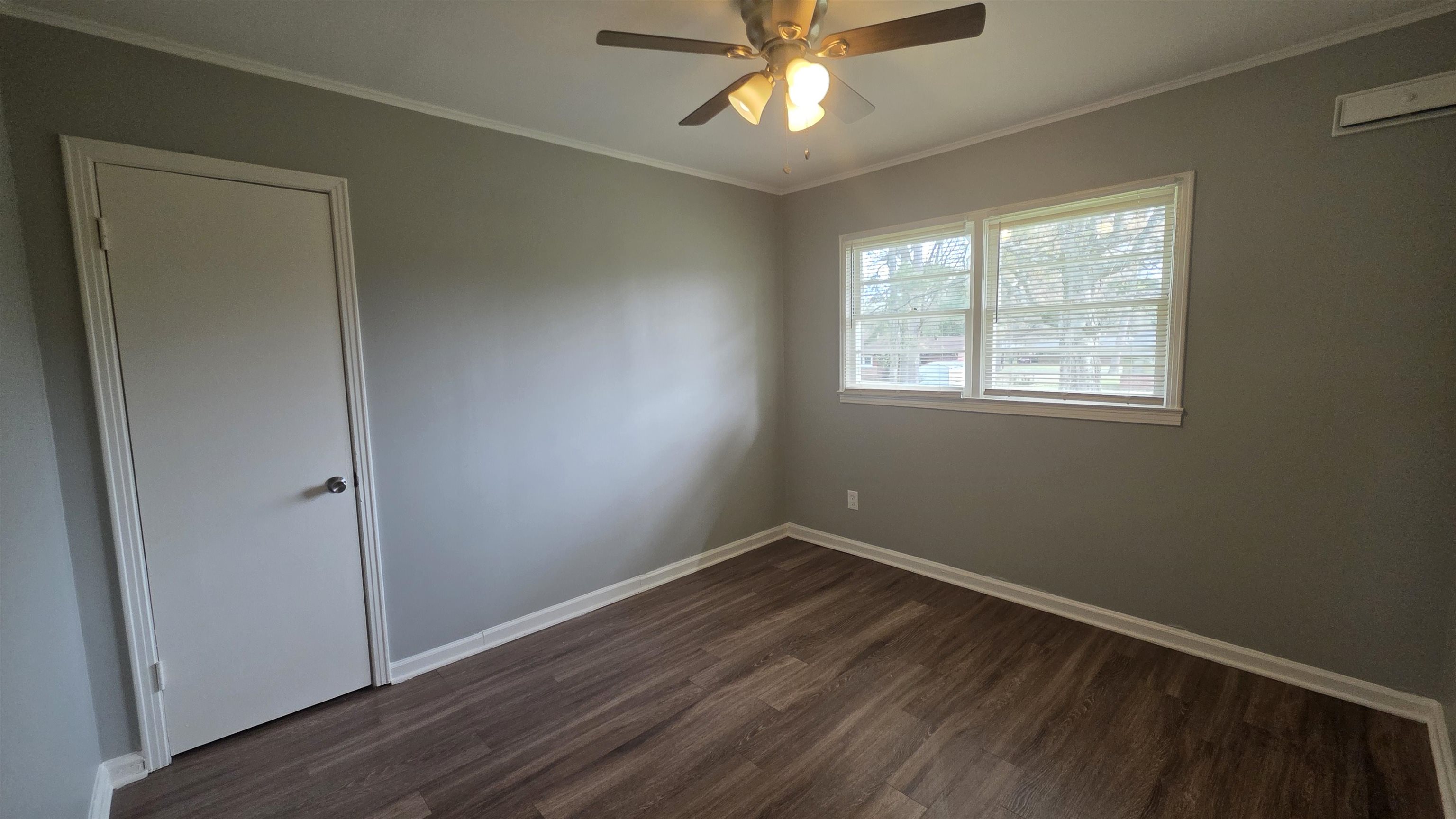 273 Clower Road Memphis, TN 38109 - Photo 8 of 11 an empty room with wooden floor fan and windows