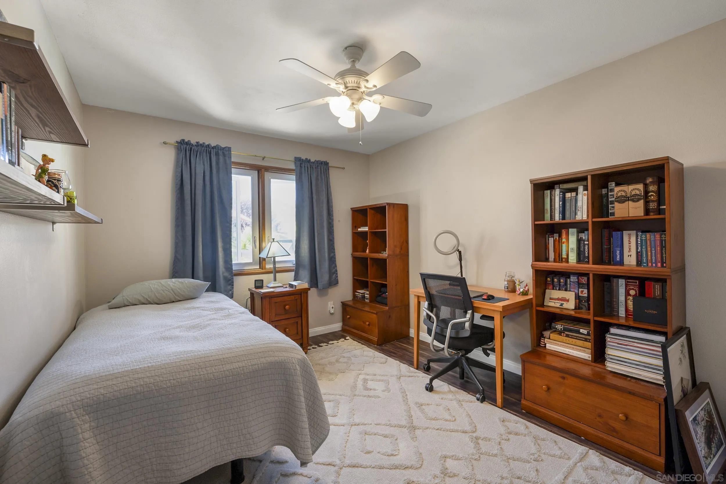 4652 Briar Ridge Road Oceanside, CA 92056 - Photo 19 of 34 a bedroom with a bed cabinets and book shelf