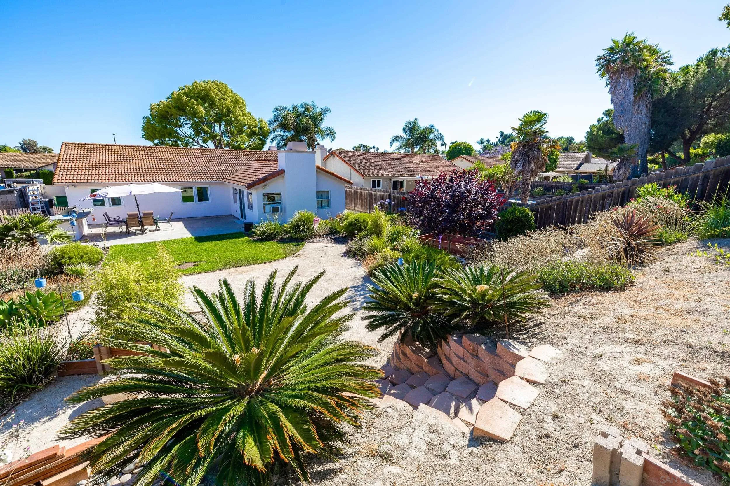 4652 Briar Ridge Road Oceanside, CA 92056 - Photo 28 of 34 a view of a house with a yard and a wooden fence