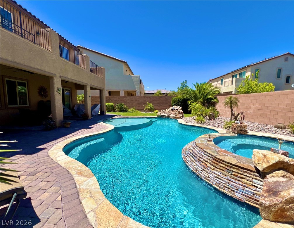 9724 University Ridge Avenue Las Vegas, NV 89149 - Photo 29 of 61 A private backyard oasis awaits, featuring a custom pool, integrated spa, and desert-inspired landscaping.