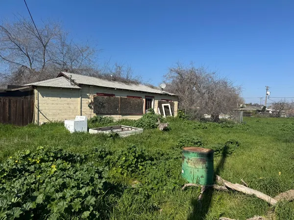 a backyard of a house with table and chairs