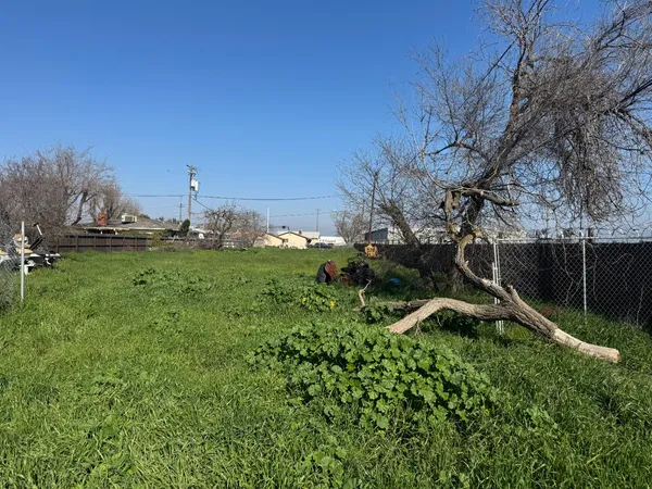 a view of a green field with wooden fence