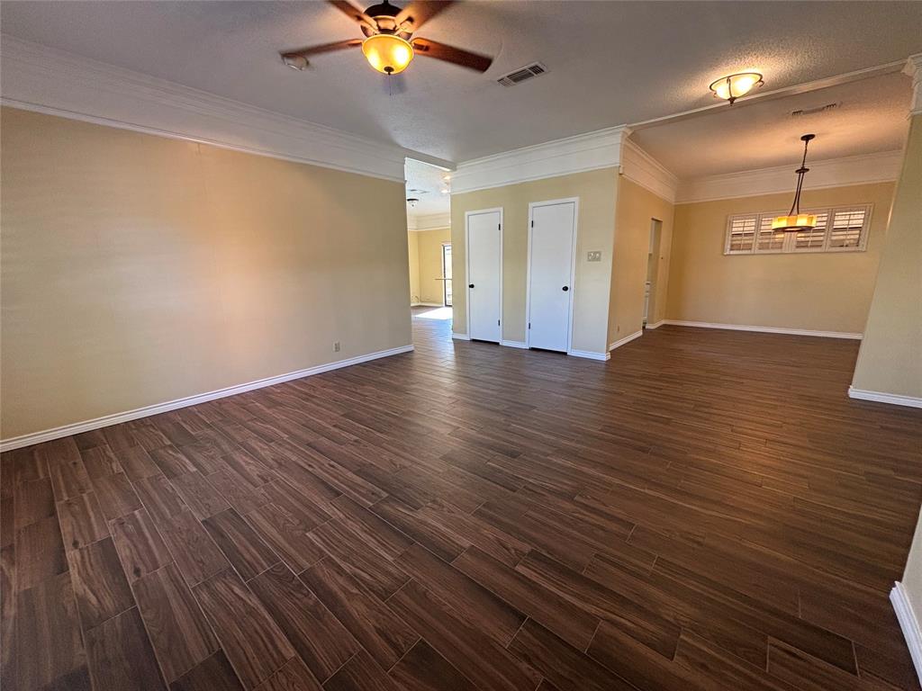 4702 Ranch View Road Fort Worth, TX 76109 - Photo 10 of 40 Wood-finish tile flooring throughout, crown molding details, white trim, and a ceiling fan with integrated lighting