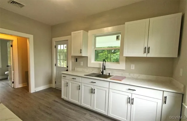 a kitchen with stainless steel appliances granite countertop a sink a stove and a white wooden cabinets