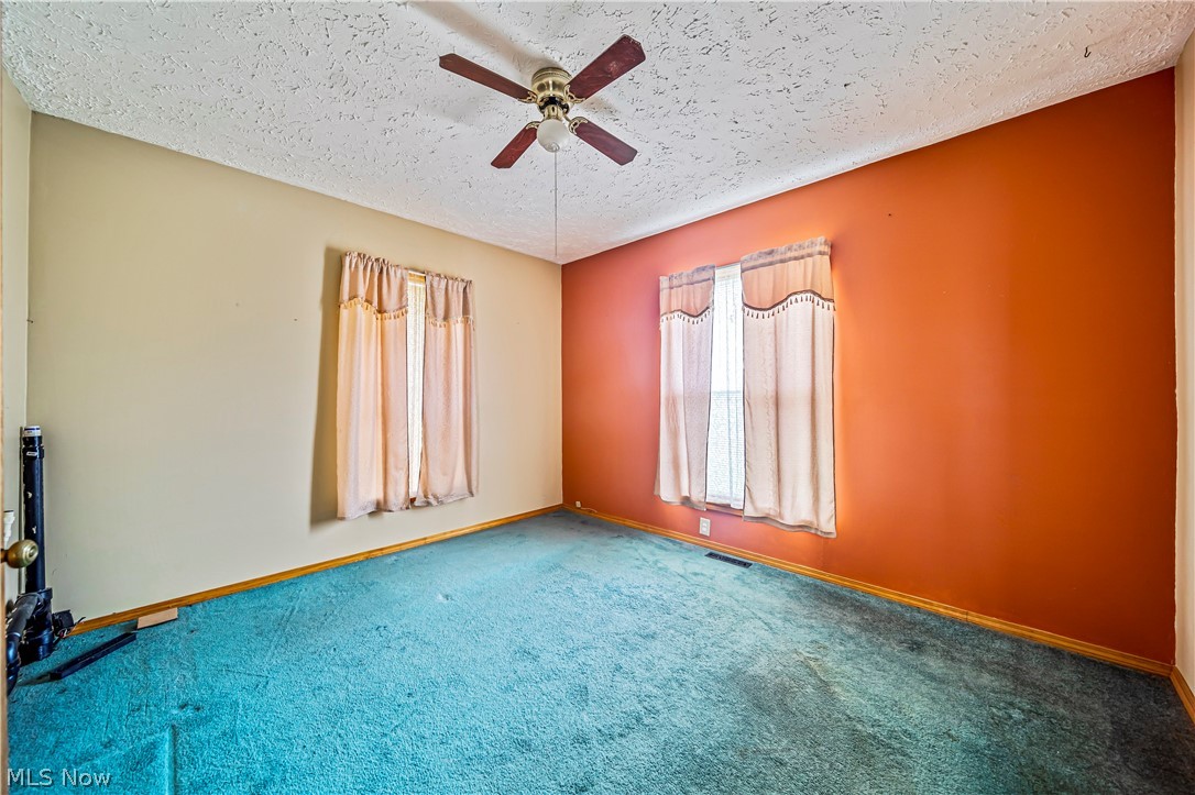 116 South Cedar Street Geneva, OH 44041 - Photo 12 of 35 First floor Bedroom featuring ceiling fan, carpet floors, and a textured ceiling, Laundry hook up