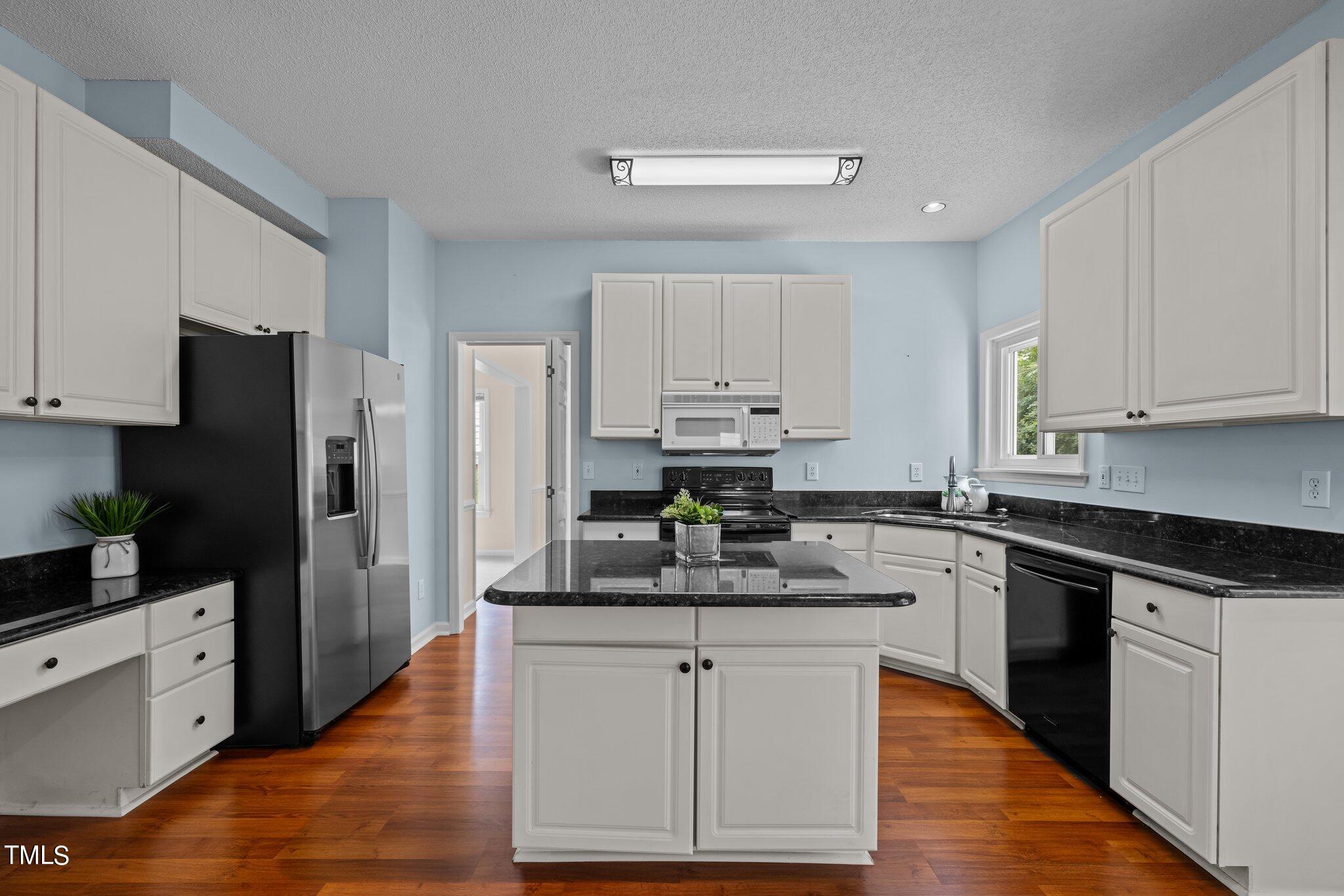 9421 Tweeds Mill Road Raleigh, NC 27617 - Photo 12 of 33 a kitchen with stainless steel appliances white cabinets granite counter tops and a stove