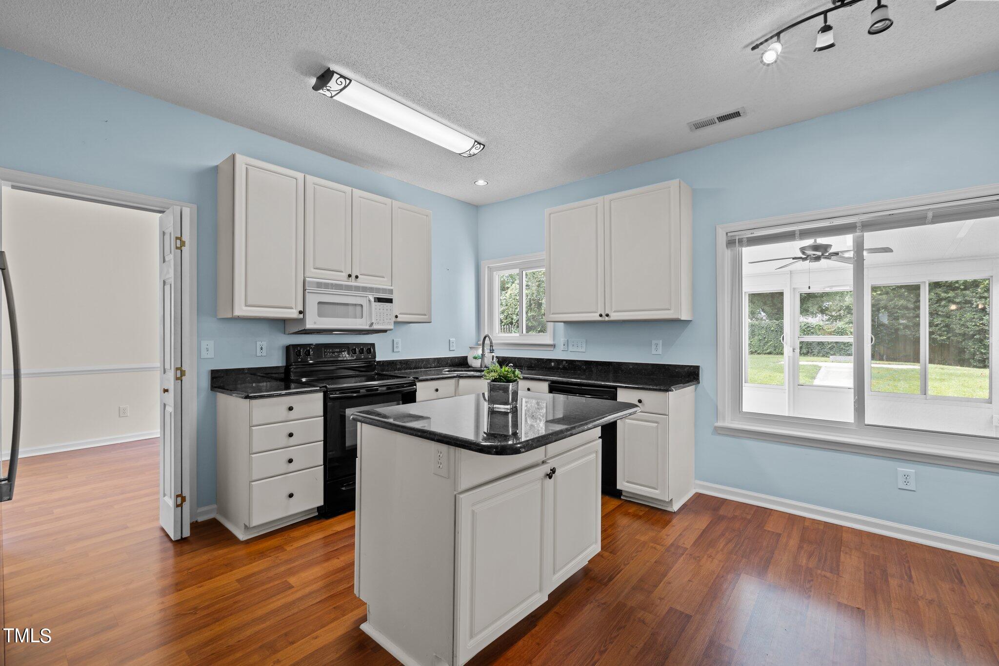 9421 Tweeds Mill Road Raleigh, NC 27617 - Photo 13 of 33 a kitchen with granite countertop white cabinets and white appliances