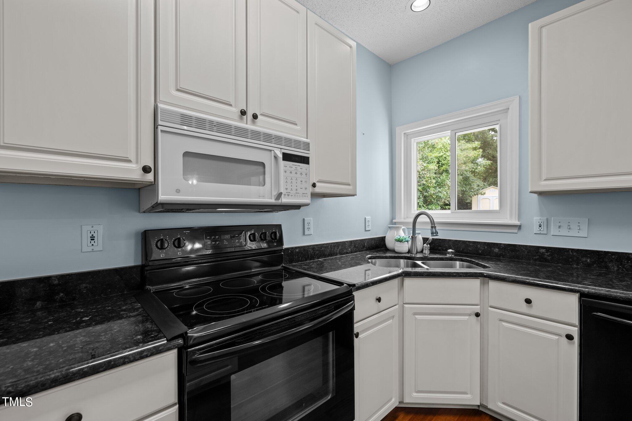 9421 Tweeds Mill Road Raleigh, NC 27617 - Photo 14 of 33 a kitchen with granite countertop white cabinets and appliances