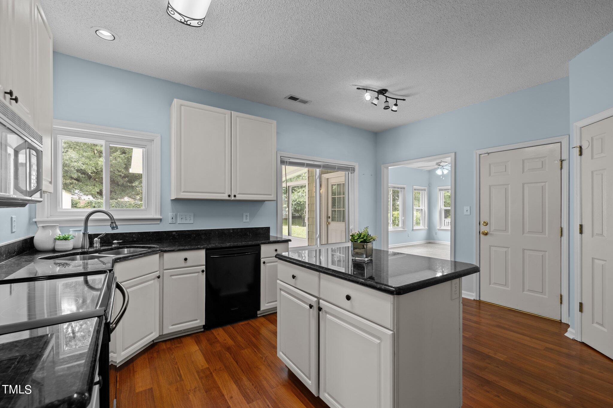 9421 Tweeds Mill Road Raleigh, NC 27617 - Photo 15 of 33 a kitchen with stainless steel appliances granite countertop a sink cabinets and wooden floor