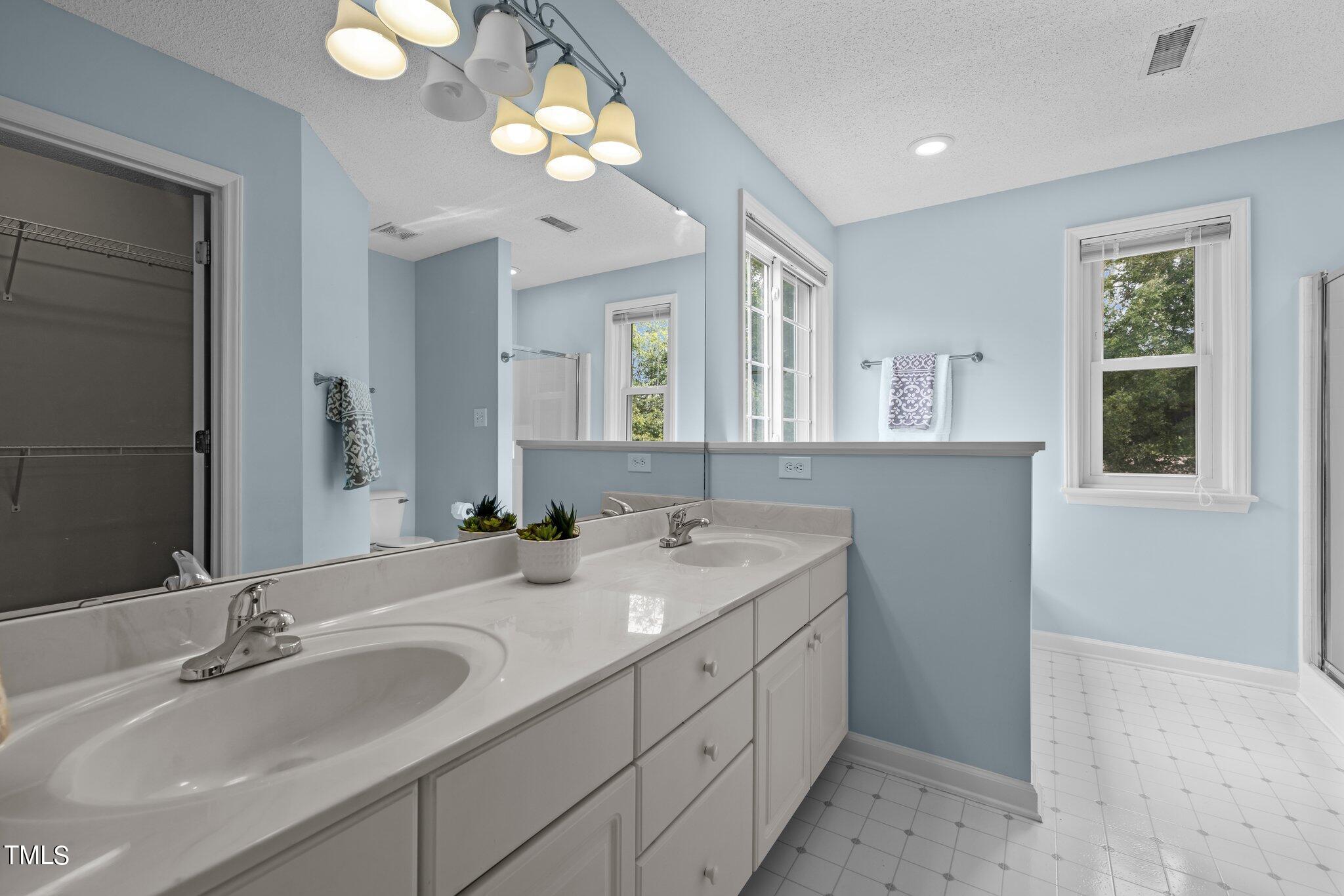 9421 Tweeds Mill Road Raleigh, NC 27617 - Photo 20 of 33 a bathroom with double vanity sink a vanity and a mirror