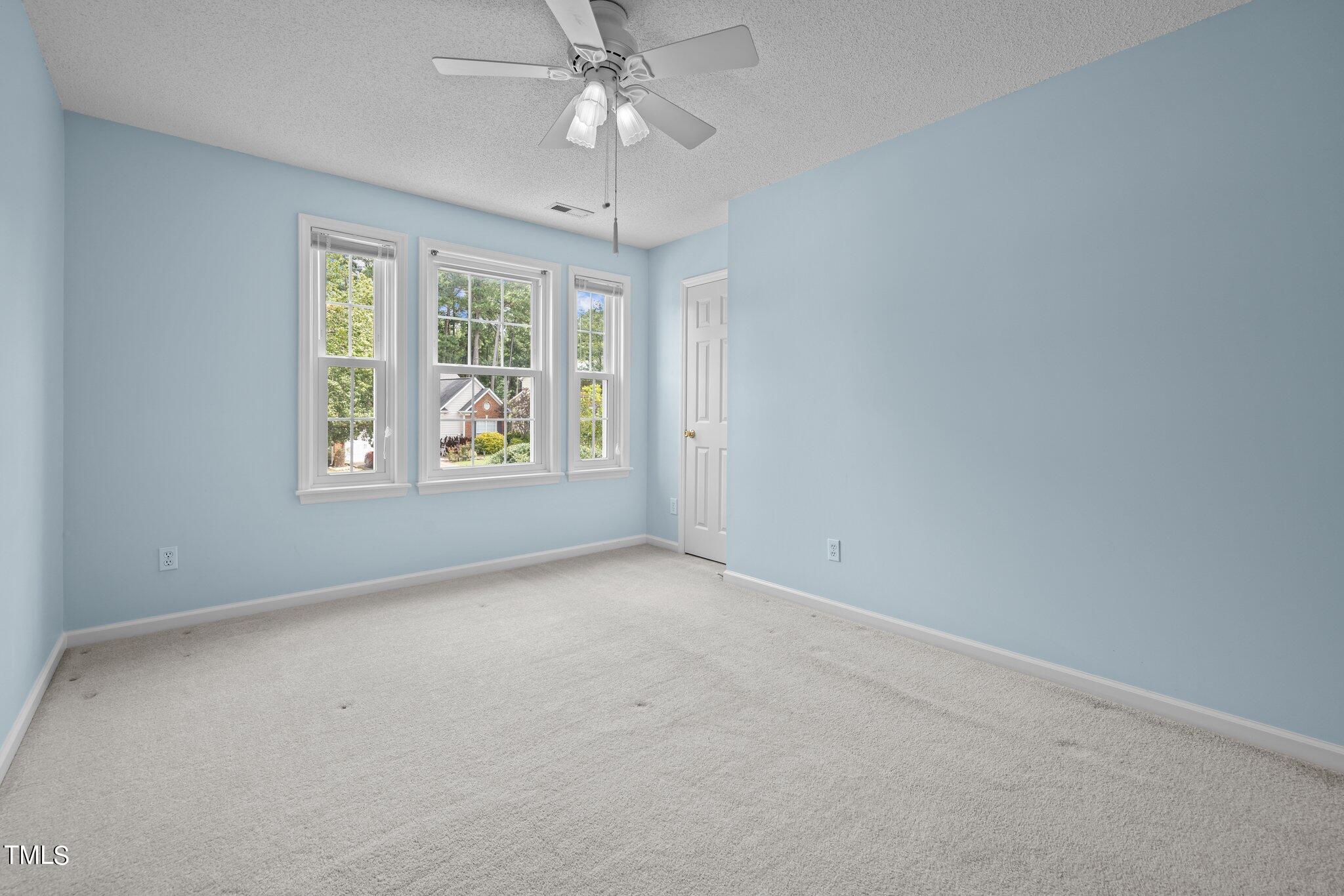 9421 Tweeds Mill Road Raleigh, NC 27617 - Photo 24 of 33 an empty room with windows and fan