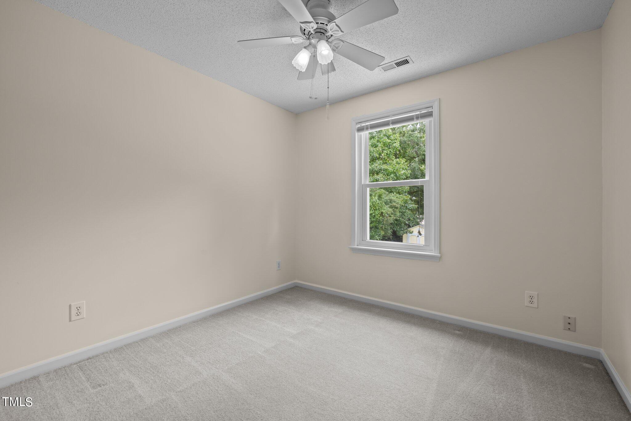 9421 Tweeds Mill Road Raleigh, NC 27617 - Photo 25 of 33 an empty room with a window and a fan