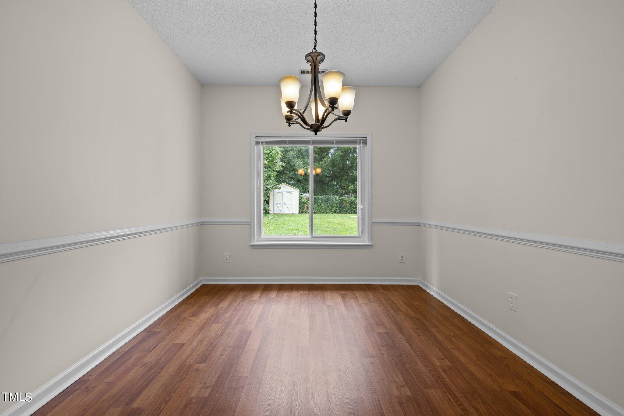 9421 Tweeds Mill Road Raleigh, NC 27617 - Photo 8 of 33 a window in an empty room with wooden floor