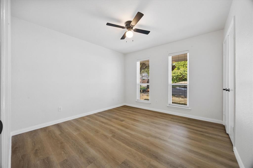 925 Lake North Road Rowlett, TX 75089 - Photo 23 of 37 Wood-finish flooring, white walls, two windows with blinds, and an attached ceiling fan with lighting