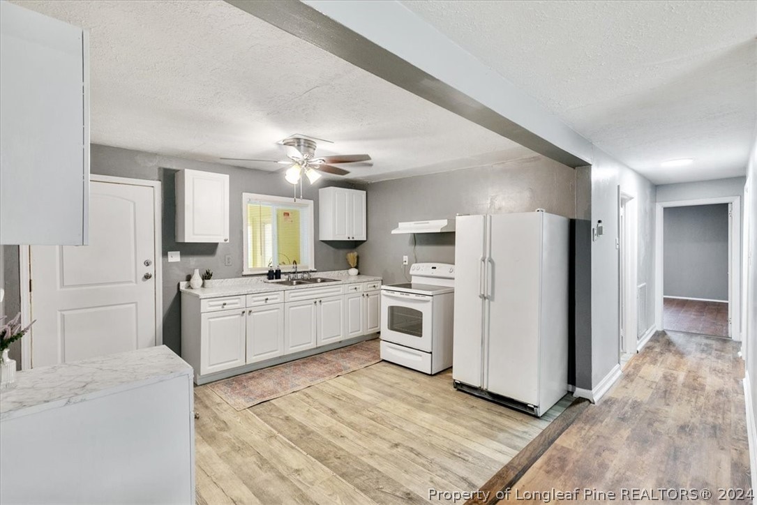 650 McKay Drive Spring Lake, NC 28390 - Photo 14 of 37 a kitchen with white cabinets and stainless steel appliances