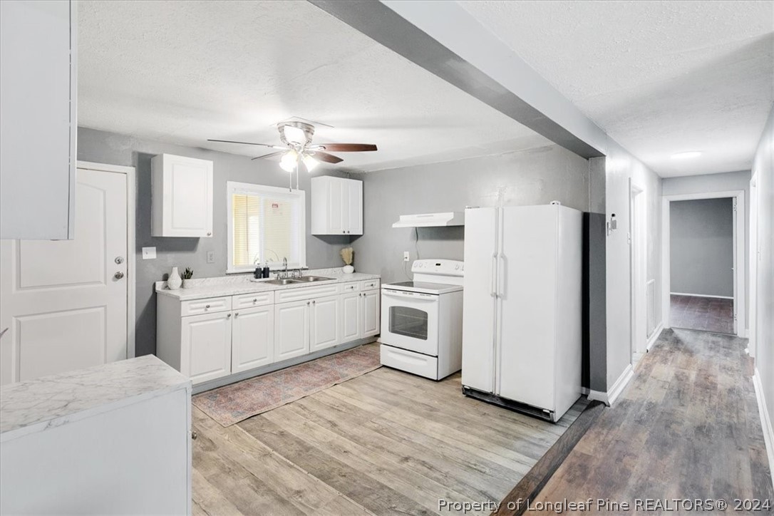 650 McKay Drive Spring Lake, NC 28390 - Photo 24 of 37 a kitchen with white cabinets and white appliances