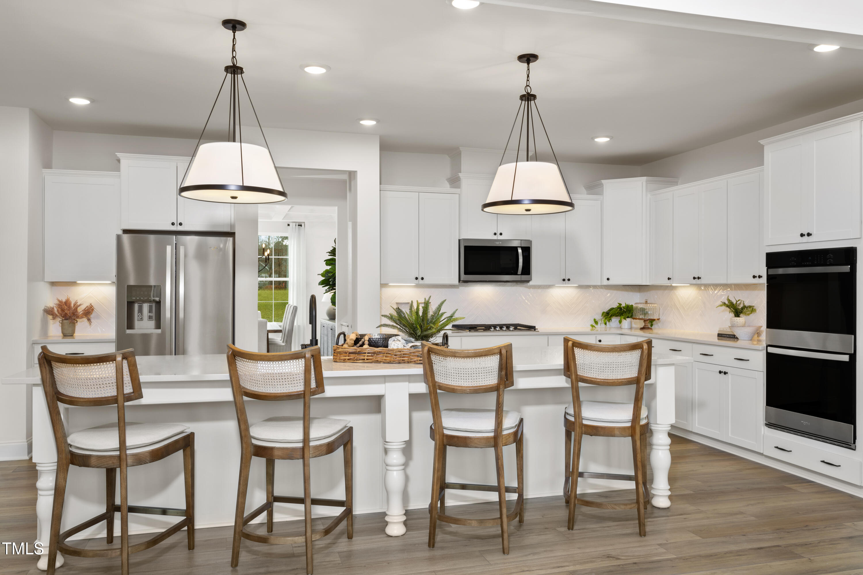 315 Adams Pointe Court Angier, NC 27501 - Photo 9 of 25 a kitchen with stainless steel appliances kitchen island granite countertop a dining table chairs and white cabinets