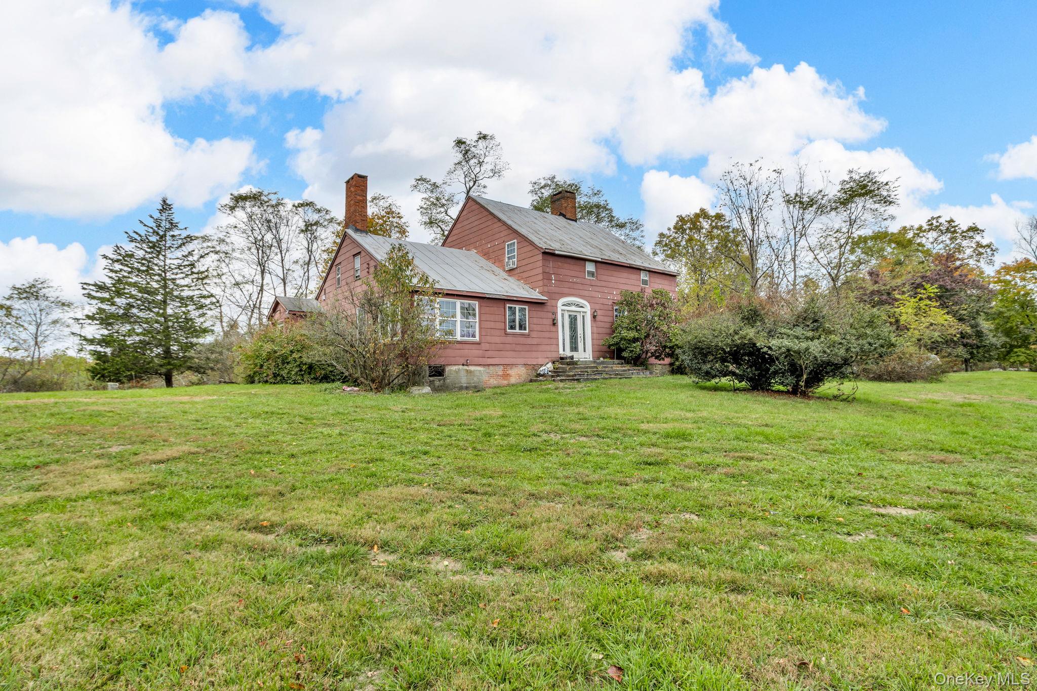 a view of a house with a big yard and potted plants