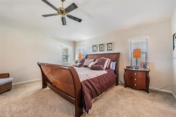 a bedroom with a bed and a chandelier fan