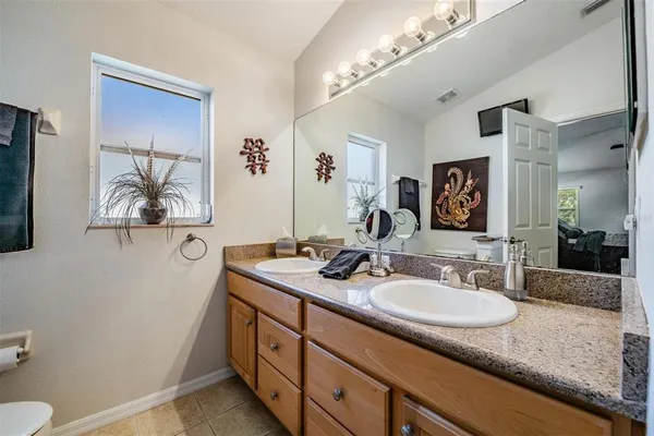a bathroom with a granite countertop sink and a mirror