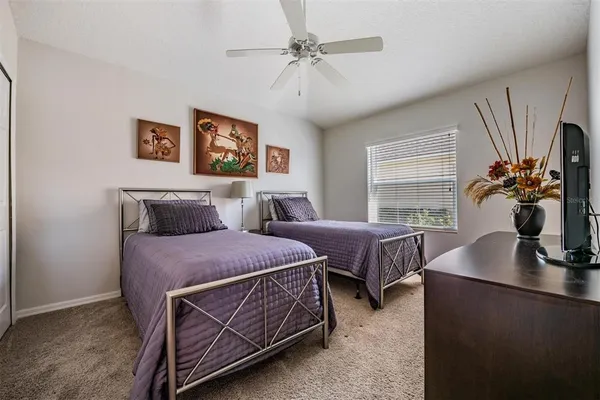 a spacious bedroom with two beds and a chandelier
