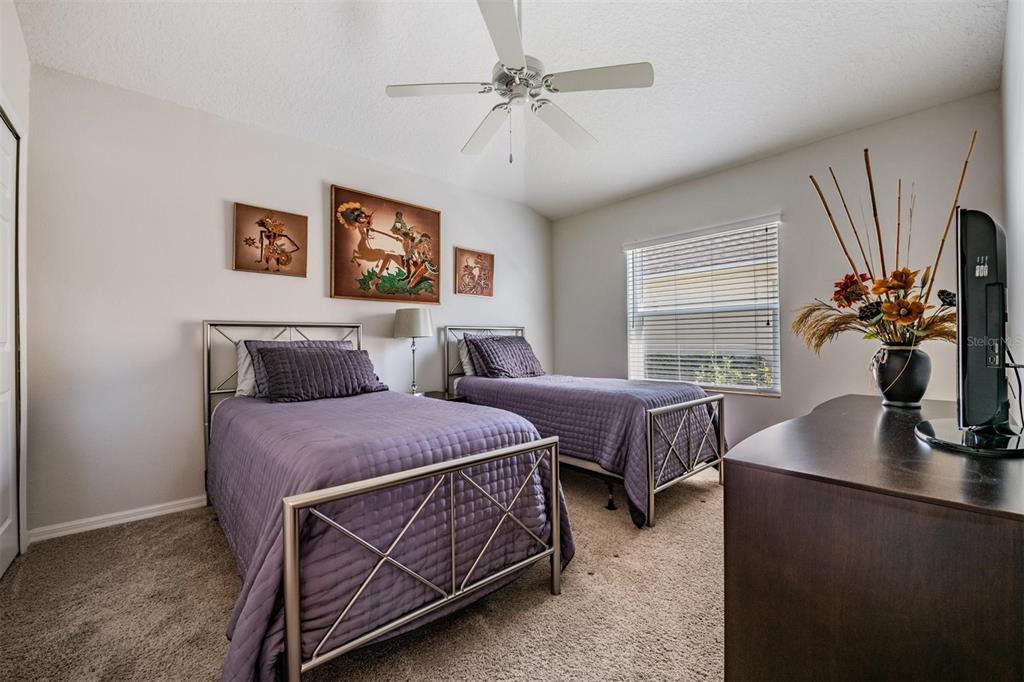 1751 Lakestone Drive Trinity, FL 34655 - Photo 19 of 51 a spacious bedroom with two beds and a chandelier