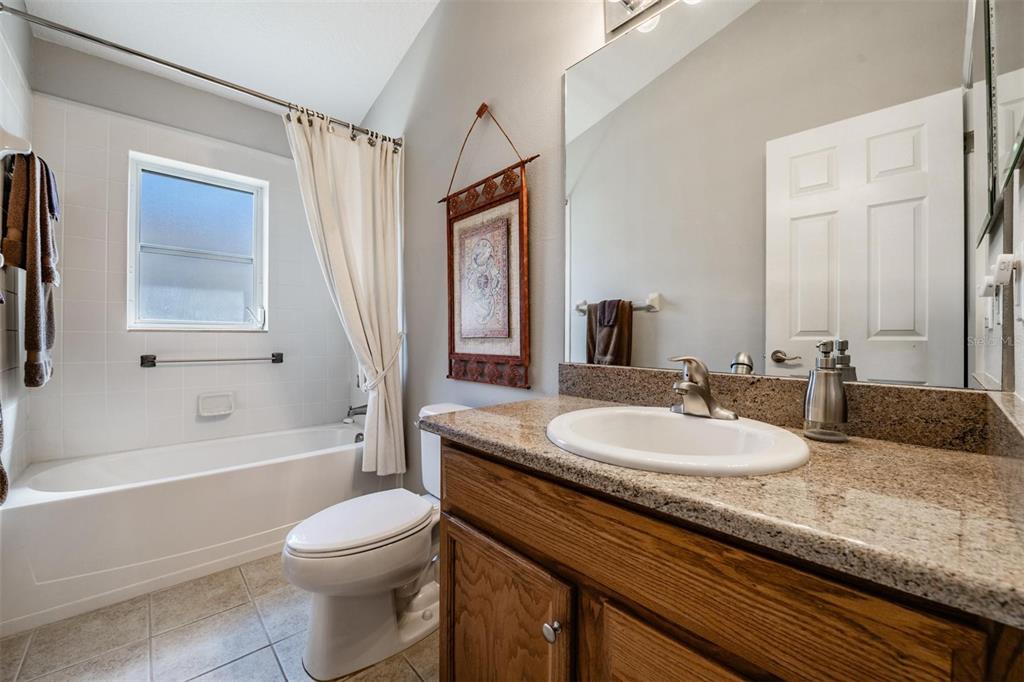1751 Lakestone Drive Trinity, FL 34655 - Photo 20 of 51 a bathroom with a granite countertop sink toilet mirror and bathtub
