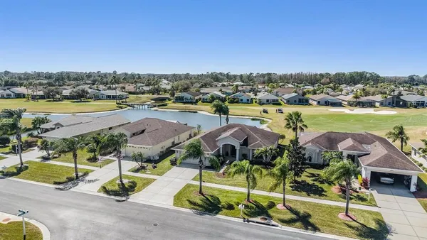 an aerial view of residential houses with outdoor space and lake view