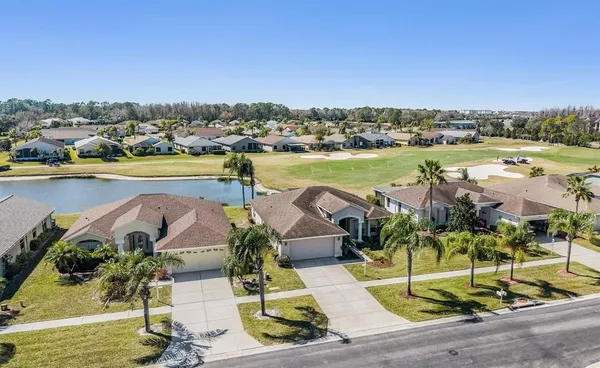 an aerial view of a house with outdoor space and lake view in back