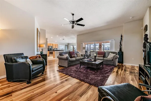 a living room with furniture or wooden floor and a ceiling fan