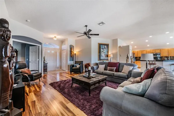 a living room with furniture a ceiling fan and a rug