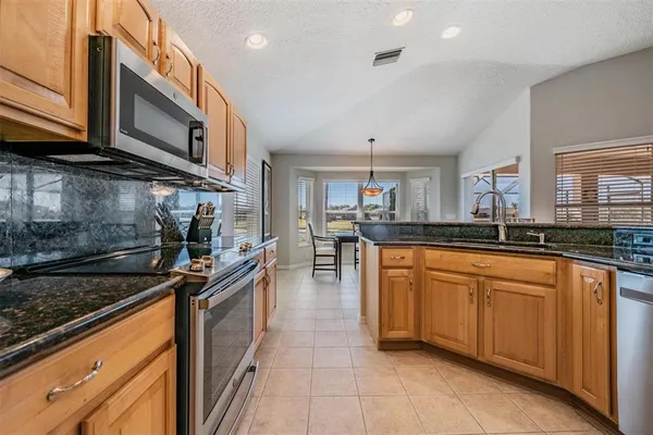 a kitchen with stainless steel appliances granite countertop a sink and cabinets