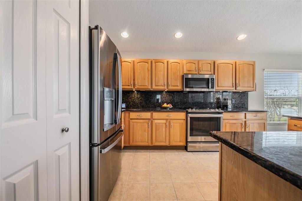 1751 Lakestone Drive Trinity, FL 34655 - Photo 10 of 51 a kitchen with kitchen island granite countertop a stove top oven a sink a counter space and cabinets