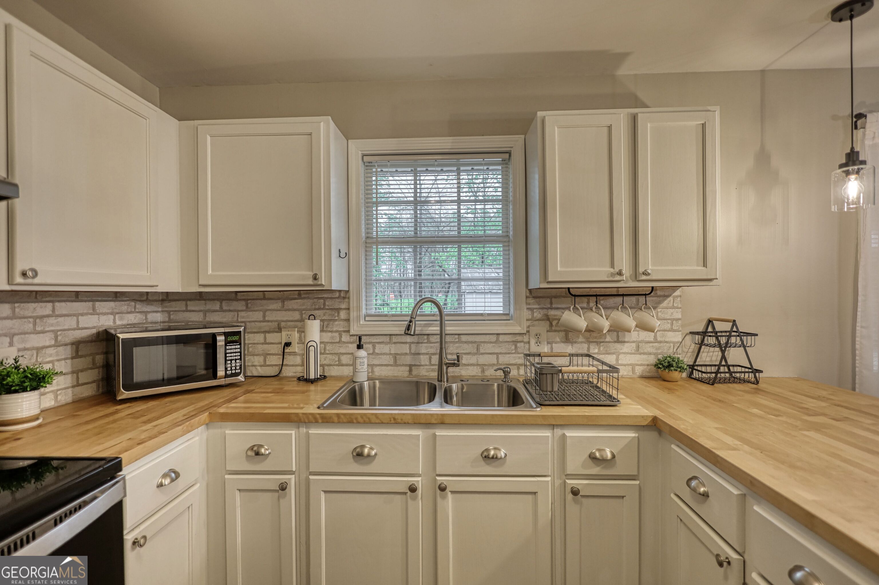 30 Waters Street Monticello, GA 31064 - Photo 9 of 40 a kitchen with stainless steel appliances granite countertop white cabinets a sink and dishwasher