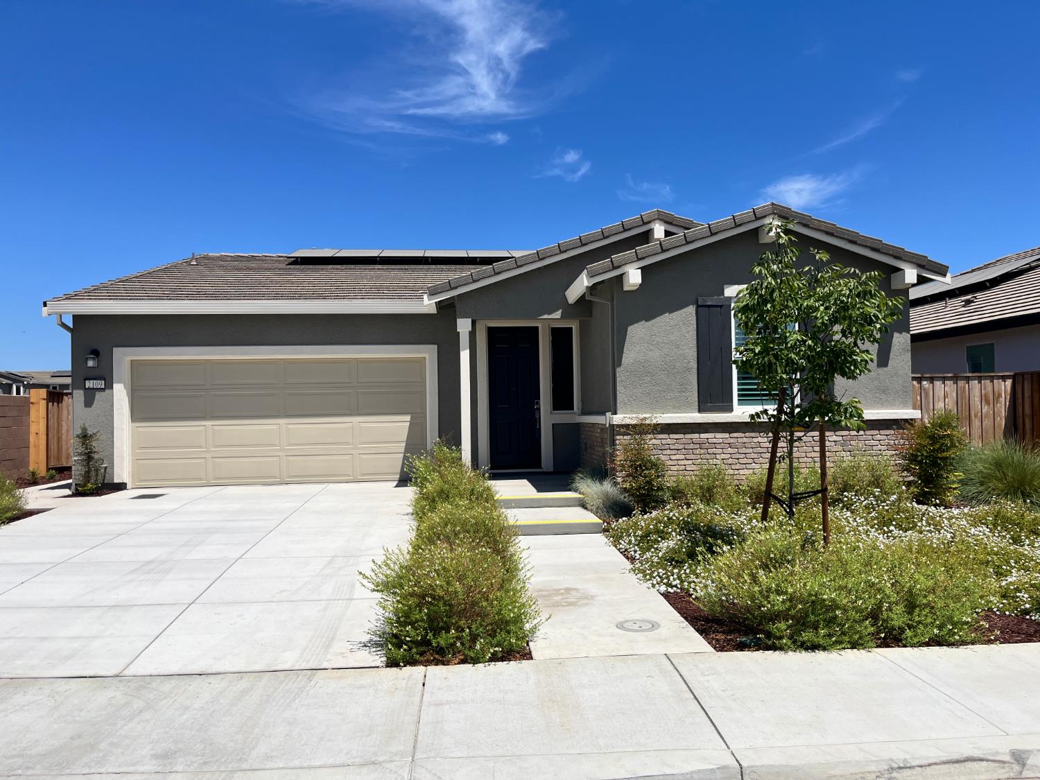 a front view of a house with a garden