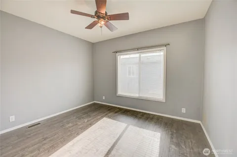 an empty room with a window and a fan