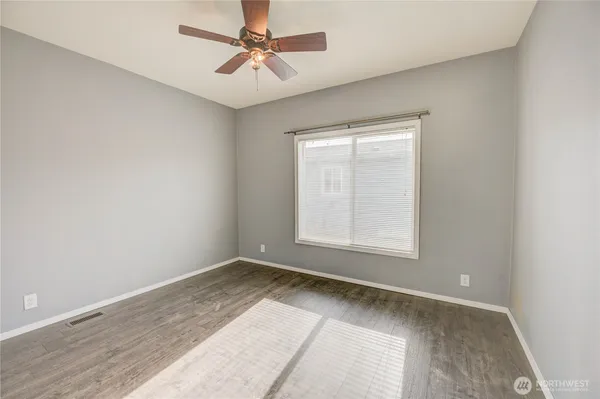an empty room with a window and a fan