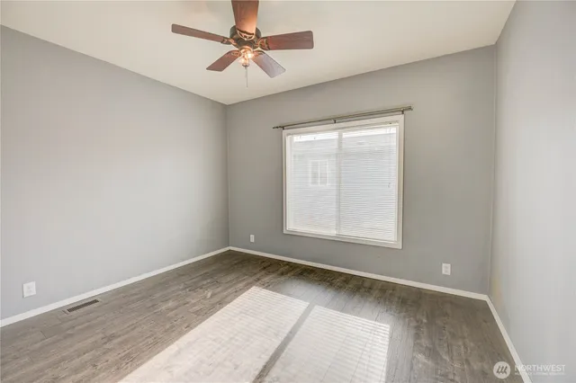an empty room with a window and a fan