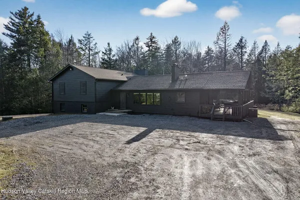 a front view of a house with a yard and trees